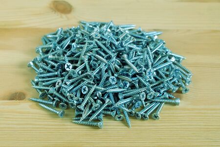 Close up of many metal screws on wooden background, Concept of construction and Industrial