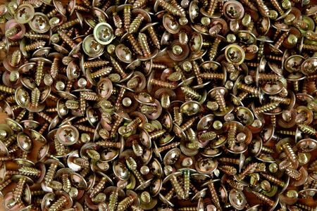Close up of many metal screws, Construction and Industrial abstraction background.