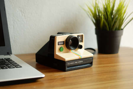 Bangkok, Thailand - March 8, 2020 Polaroid land camera 1000 old used instant camera with laptop...
