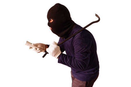 Masked thief holds steel crowbar in preparation for a pry and shines his torch Isolated on white backgroundの写真素材