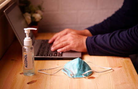 Business men working from home with Surgical mask or hygienic mask N95 on laptop computer with Sanitizer alcohol gel for hand. Protection factors for covid-19, corona virus, pm2.5の写真素材