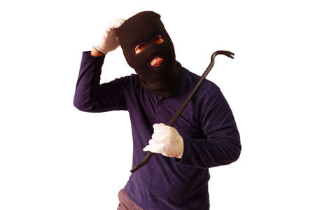 Masked thief holds steel crowbar in preparation for a pry, turned to look with a doubtful expression Isolated on white backgroundの写真素材