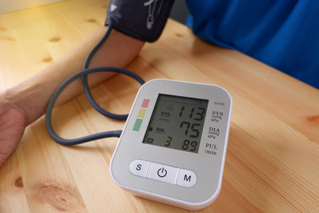 Old man checking his blood pressure and heart rate health with digital blood pressure monitor. The concept of hypertension and the elderly and health careの写真素材