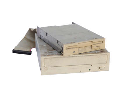 Pile of rusty, old and obsolete computer hardware, like a CD-ROM, floppy disk, isolated on a white backgroundの写真素材