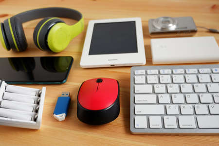 Smartphone with Headphones and ebook reader and other electronic gadgets on wooden background.の写真素材