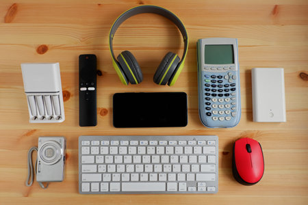Smartphone with portable game consoles and ebook reader and other electronic gadgets on wooden...