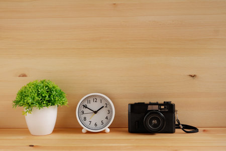 Table clocks and flower vases and film cameras on wooden desks. with copy space for text.