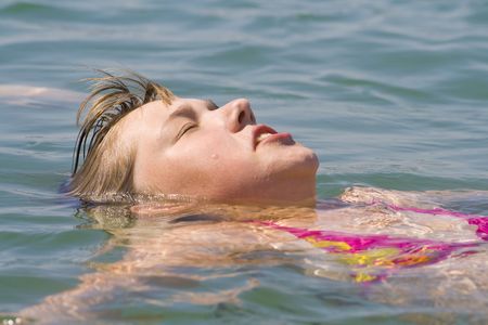 The cheerful girl swimming in the seaの写真素材
