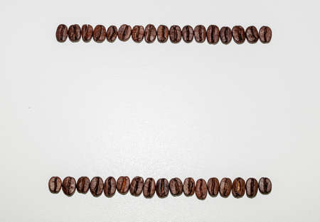 black coffee grains laid in the form of a frame on a white background, removed from aboveの写真素材