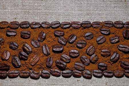 black coffee grains and ground coffee laid in the form of a frame on a coarse linen cloth, removed from aboveの写真素材