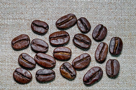 black coffee grains scattered on coarse linen cloth, taken from above close-upの写真素材