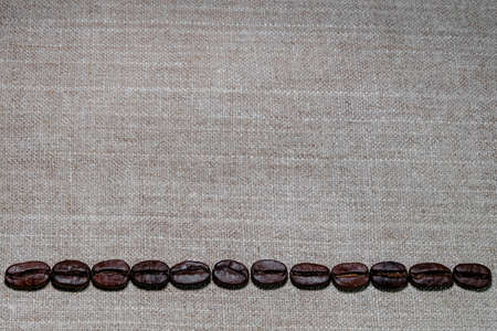 black coffee grains laid in the form of a frame on a coarse linen cloth, removed from aboveの写真素材