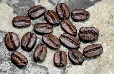 black coffee grains scattered on a stone background, photographed from above close-upの写真素材