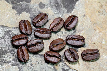 black coffee grains scattered on a stone background, photographed from above close-upの写真素材