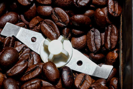 black coffee grains poured into an electric coffee grinder, taken from above close-upの写真素材