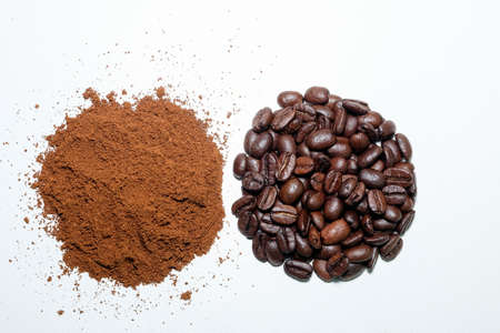 black coffee grains and ground coffee, poured in two handful on a white background, shot from above close-upの写真素材