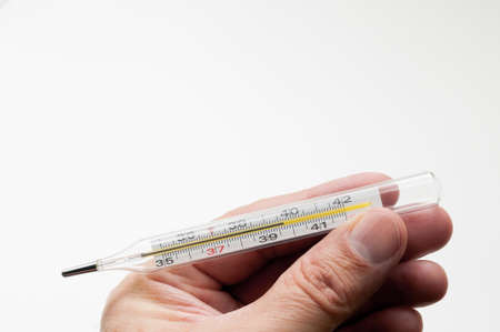 Mercury thermometer in hand on a white background. High quality photoの写真素材