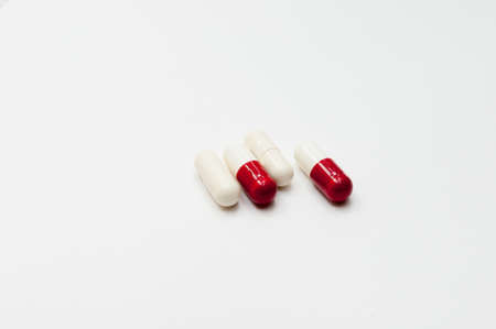 Red and white capsules on a white background. Close-up.の写真素材
