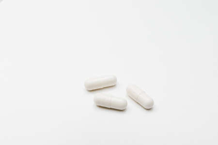White pills on a white background. The concept of treatment of diseases.の写真素材