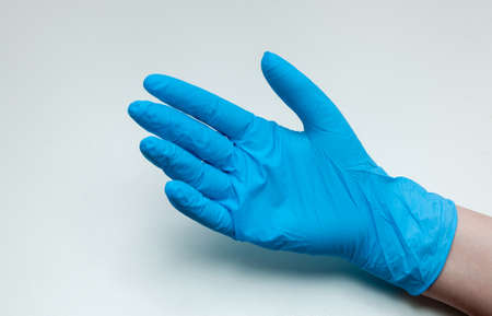 Hand in blue medical gloves on a white background. Coronavirus concept.の写真素材