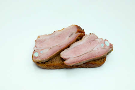 Sandwich with rye bread and two pieces of fried pork on a white backgroundの写真素材