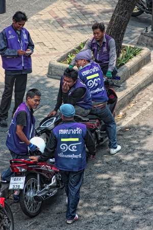 BANGKOK, THAILAND - MARCH 22: Unidentified purple shirt motorcycle taxi drivers wait for passengers near the silom MRT stop in Bangkok, Thailand on March 22, 2011.のeditorial素材
