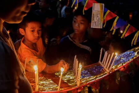 Luang Prabang, Laos - October 9: Unidentified kids bring a boat offering to the Mekong river on Wan Ok Phansa on October 9, 2014 in Luang Prabang, Laos.のeditorial素材