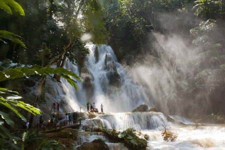 LUANG PRABANG, LAOS - OCTOBER 10: Unidentified tourists at the main waterfall at Kuang Si Waterfall near Luang Prabang, Laos on October 10, 2014.の写真素材