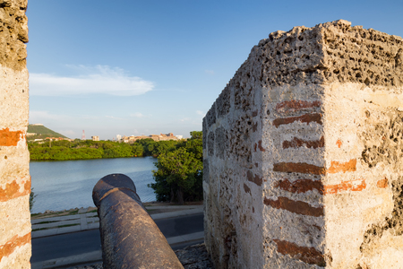 A cannon faces the Castillo de San Felipe de Barajas and Convento de Santa Cruz de la Popa in Cartagena, Colombia.の写真素材