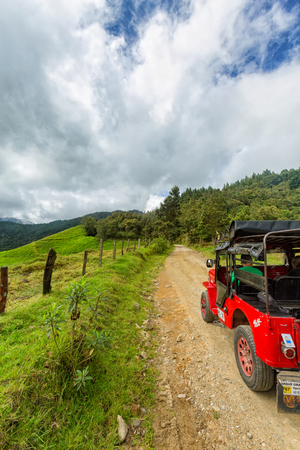 SALENTO, COLOMBIA - JUNE 7: A red jeep parked near pastures in the mountains outside of Salento, Colombia on June 7, 2016.のeditorial素材