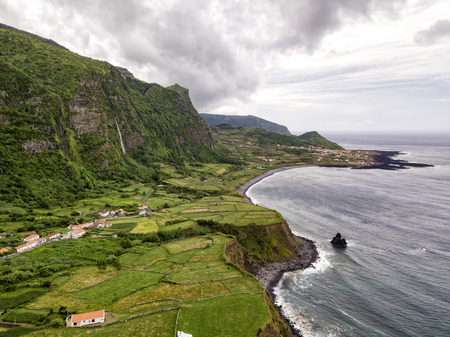 Aerial view of waterfalls and a rocky beach next to the towns of Ponta da Faja and Faja Grande on the island of Flores, Azores in Portugal.の写真素材
