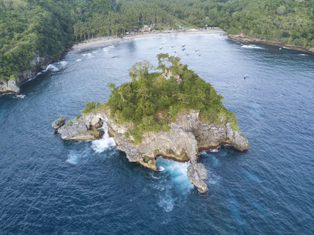 The tiny island of Pulau Batumejinong with a small hindu shrine in the small bay of Crystal Beach on...