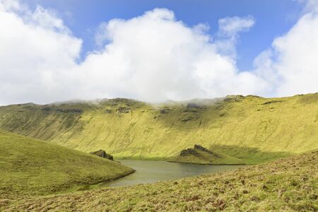 Sunlight illuminates the rim of the Corvo caldera on the island of Corvo in the Azores, Portugal. の写真素材