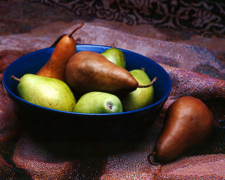 Green and brown pears in bowl.の写真素材