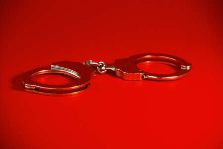 pair of handcuffs on a red backgroundの写真素材
