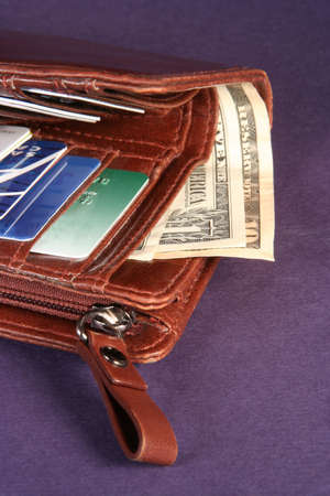 Brown wallet showing credit cards and moneyの写真素材