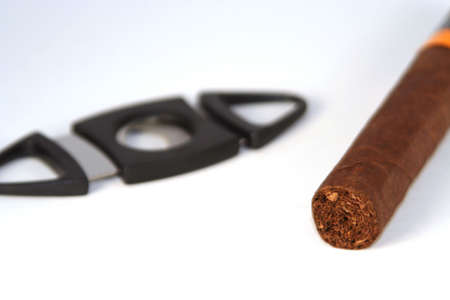  Photo of a cigar with a black cigar clipper in the backgroundの写真素材