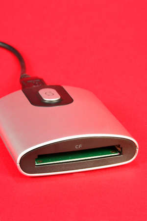 Silver memory card reader on a red background showing symbol for usb