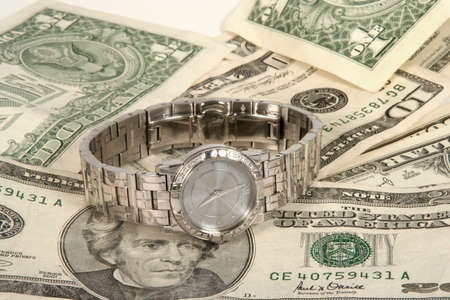 Wrist watch on a pile of money