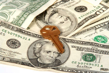  House key laying on a pile of moneyの写真素材