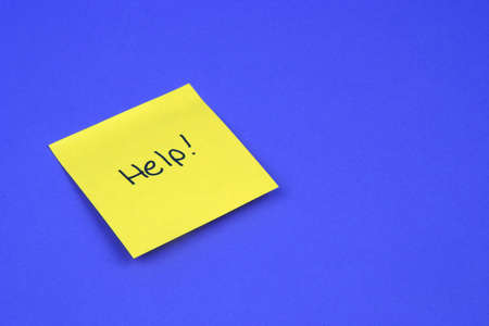 Help written on a yellow sticky note on a blue backgroundの写真素材