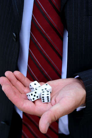 Closeup of dice in hand of man wearing suitの写真素材