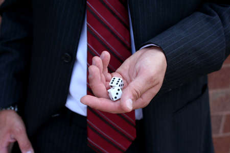 Closeup of dice in hand of man wearing suitの写真素材