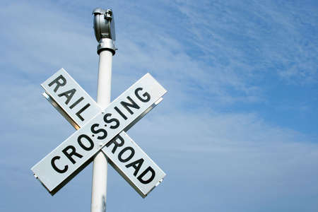 Railroad crossing sign against blue skyの写真素材