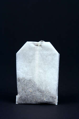 Unused tea bag standing up on a black backgroundの写真素材