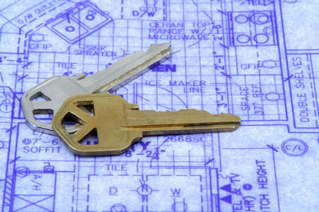 House keys laying over a blueprint of houseの写真素材