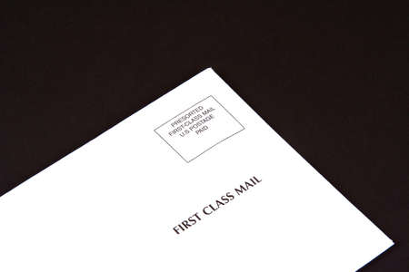 Corner of envelope of first class mail on a black envelopeの写真素材