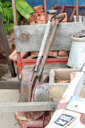 Two shovels leaning against a wooden fenceの写真素材