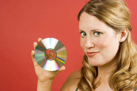 Young woman on red holding a cdの写真素材