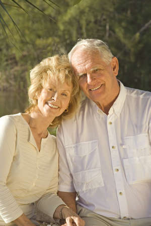 Happy senior couple sitting in a park.